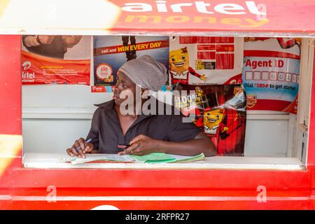 Telefonkartenverkäufer in ihrem Stand auf dem Jinja Markt, Uganda. Stockfoto