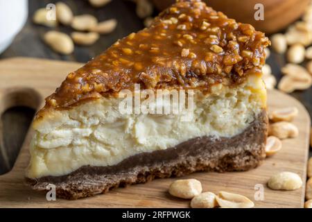 Käsekuchen aus Milchprodukten und Erdnüssen in Karamell, köstliches Dessert mit Erdnüssen, die in Stücke geschnitten werden, um in einem Café Tee zu machen Stockfoto