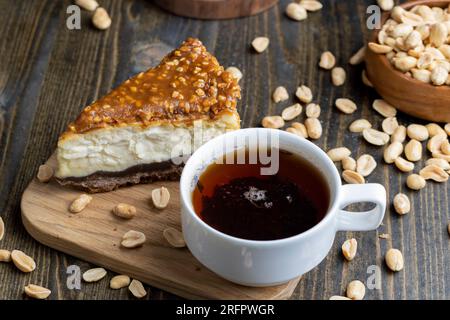 Käsekuchen aus Milchprodukten und Erdnüssen in Karamell, köstliches Dessert mit Erdnüssen, die in Stücke geschnitten werden, um in einem Café Tee zu machen Stockfoto