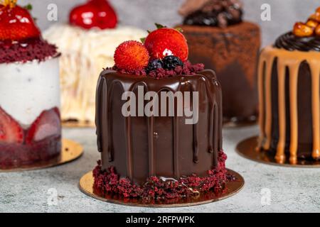 Sorten Kuchen. Auswahl an Schokolade- und Obstkuchen auf grauem Hintergrund Stockfoto