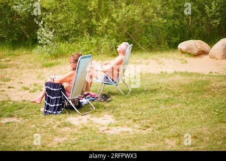 Posen, Polen - 23. Juli 2023: Eine Person, die auf einem Stuhl an einem Sandstrand sitzt Stockfoto