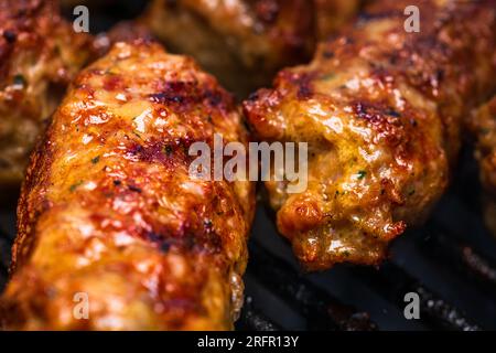 Traditionelle rumänischen Fleischbällchen "mici" auf dem Grill. Schmackhafte Fleischbällchen auf dem Grill, Schweinefleisch auf Holzkohlengrill Stockfoto