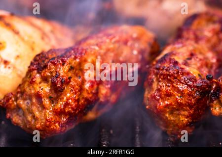 Traditionelle rumänischen Fleischbällchen "mici" auf dem Grill. Schmackhafte Fleischbällchen auf dem Grill, Schweinefleisch auf Holzkohlengrill Stockfoto