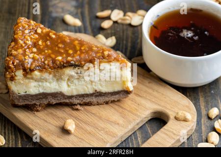 Käsekuchen aus Milchprodukten und Erdnüssen in Karamell, köstliches Dessert mit Erdnüssen, die in Stücke geschnitten werden, um in einem Café Tee zu machen Stockfoto