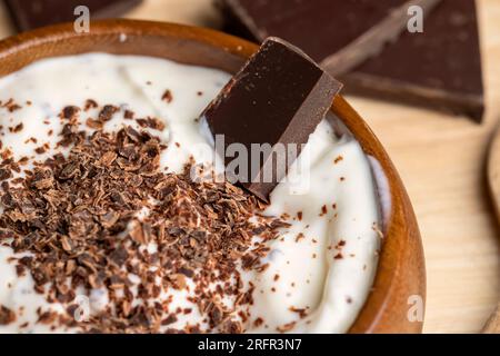 Joghurt aus Sahne mit Schokoladenstücken und Krümeln, hausgemachter Joghurt aus Milchprodukten mit Milchschokolade Stockfoto