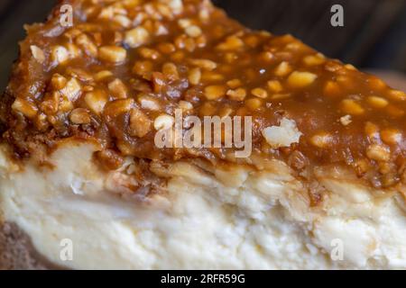 Käsekuchen aus Milchprodukten und Erdnüssen in Karamell, köstliches Dessert mit Erdnüssen, die in Stücke geschnitten werden, um in einem Café Tee zu machen Stockfoto