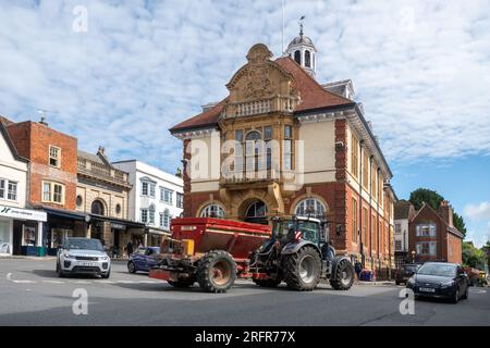 Ein Traktor und anderer Verkehr, der durch das Stadtzentrum von Marlborough vor dem Rathaus in Wiltshire, England, fährt Stockfoto