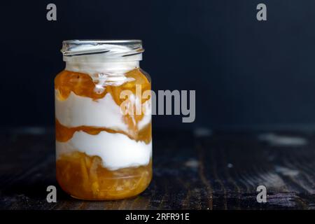 Joghurt aus frischer Milch mit süßer Zitronenmarmelade und frischen Zitronen, köstlicher Joghurt mit Zitronengeschmack Stockfoto