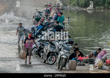 Bogor, Indonesien - 05. August 2023: Aktivitäten von Einwohnern in Bogor, Wäsche waschen und Motorräder im Fluss Stockfoto