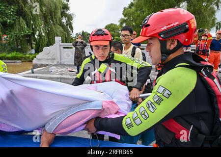 (230805) -- HARBIN, 5. August 2023 (Xinhua) -- Feuerwehrleute verlegen einen Patienten in den Bezirk Yanshou in Harbin, nordöstlich Chinas Provinz Heilongjiang, 5. August 2023. Ausgelöst durch sintflutartige Regenfälle in der Stadt Mudanjiang und der Provinzhauptstadt Harbin, haben die Wasserstände einiger Flüsse hier den Warnwasserstand überschritten. Rettungsteams, darunter örtliche Feuerwehrleute und Waldbrandwehrleute, wurden entsandt, um bei der Rettung und Hilfe zu helfen. Die 24-Stunden-Patrouillen auf den Dämmen wurden durchgeführt, um die Risiken zu kontrollieren, und die Überschwemmungen, von denen die Bewohner betroffen waren, wurden umgesiedelt. (Xinh Stockfoto