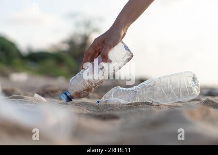 Freiwillige sammeln Plastikflaschen am Tag der Reinigung, sammeln Abfälle am Meeresstrand, Verschmutzungs- und Recycling-Konzept Stockfoto