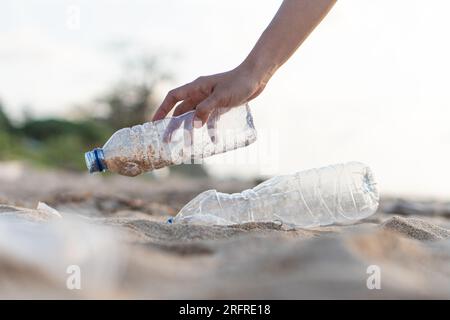 Freiwillige sammeln Plastikflaschen am Tag der Reinigung, sammeln Abfälle am Meeresstrand, Verschmutzungs- und Recycling-Konzept Stockfoto