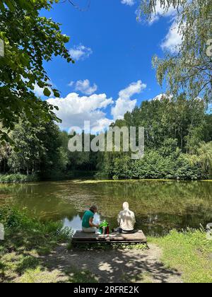 Das Seniorenpaar am See macht im Sommer Ein Picknick. Alte Leute entspannen sich im Sommer am See Stockfoto