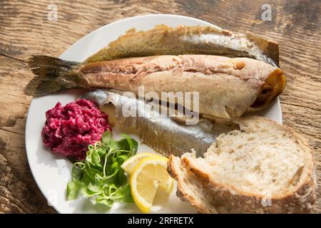 Heiße geräucherte Regenbogenforelle, Oncoryhnchus mykiss, serviert mit Meerrettich- und Rote-Bete-Sauce, Lammsalat und Zitronenscheiben. England GB Stockfoto