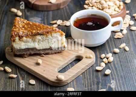 Käsekuchen aus Milchprodukten und Erdnüssen in Karamell, köstliches Dessert mit Erdnüssen, die in Stücke geschnitten werden, um in einem Café Tee zu machen Stockfoto