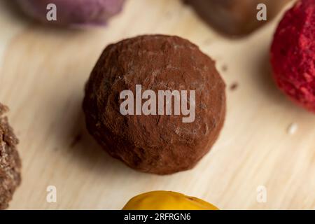 Süße Schokoladenbonbons in Form einer Kugel auf dem Tisch, Schokoladenbonbons zusammen mit anderen Süßigkeiten Stockfoto