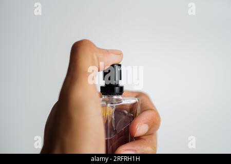 Parfümflasche auf weißem Hintergrund besprüht Stockfoto