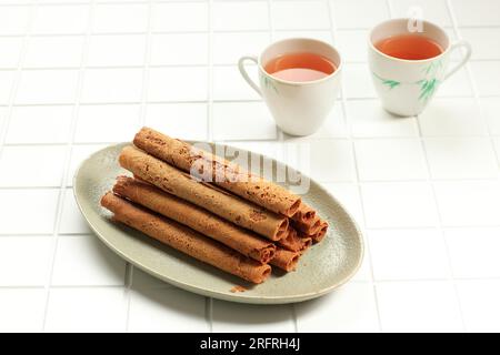 Kue Semprong chinesische Waffelei-Eierrolle, serviert mit Tee Stockfoto