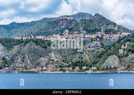 Blick vom Meer auf die auf einem Hügel gelegene Stadt Taormina in Sizilien, Italien Stockfoto