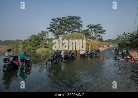 Bogor, Indonesien. 05. Aug. 2023. Einwohner, die Motorräder am Ufer des Flusses Cileungsi in Gunung Sari Village, Bogor Regency, West Java, am 05. August 2023 waschen, Da das Wasser in ihren Häusern ausgetrocknet ist, wurde es von extremen Trockenheit aufgrund des El Nino beeinflusst. (Foto: Andi M Ridwan/INA Photo Agency/Sipa USA) Guthaben: SIPA USA/Alamy Live News Stockfoto