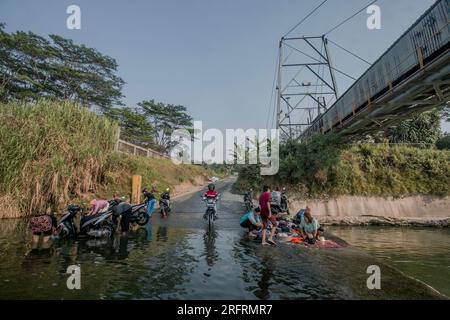 Bogor, Indonesien. 05. Aug. 2023. Einwohner, die Motorräder am Ufer des Flusses Cileungsi in Gunung Sari Village, Bogor Regency, West Java, am 05. August 2023 waschen, Da das Wasser in ihren Häusern ausgetrocknet ist, wurde es von extremen Trockenheit aufgrund des El Nino beeinflusst. (Foto: Andi M Ridwan/INA Photo Agency/Sipa USA) Guthaben: SIPA USA/Alamy Live News Stockfoto