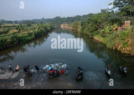 Bogor, Indonesien. 05. Aug. 2023. Am 05. August nutzen die Bewohner Flusswasser, um ihre Kleidung und ihr Motorrad am Ufer des Flusses Cileungsi in Gunung Sari Village, Bogor Regency, West Java, Indonesien, zu waschen. 2023, da das Wasser in ihren Häusern aufgrund des El Nino von extremen Trockenheit betroffen ist. (Foto: Andi M Ridwan/INA Photo Agency/Sipa USA) Guthaben: SIPA USA/Alamy Live News Stockfoto