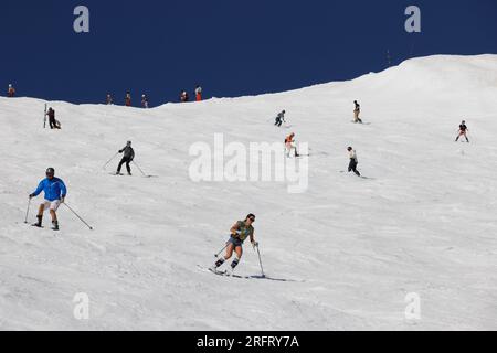 Am Mammoth Mountain gibt es zahlreiche Skifahrer und Snowboarder, die den amerikanischen Unabhängigkeitstag mit einer Fahrt auf der Cornice Bowl Run feiern. Stockfoto