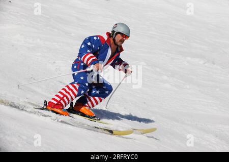 Mammoth Lakes, Kalifornien. 4. Juli 2023. Ein Mann mittleren Alters mit Schnurrbart und einteiligen Skiern mit amerikanischer Flagge am Mammoth Mountain. Stockfoto
