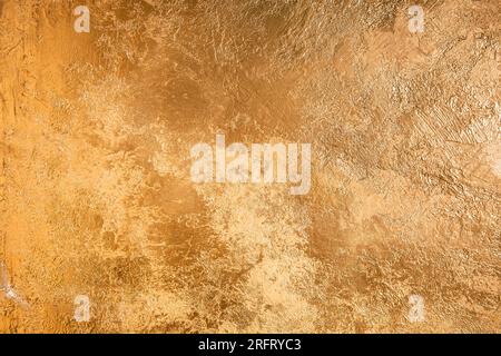 Goldfarbener strukturierter Hintergrund mit metallischem Schimmer, reichhaltiger rauer Oberfläche und elegantem luxuriösem abstraktem Muster. Stockfoto