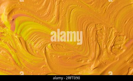 Hellgelbe und orange Acrylstruktur mit dicken, wirbelnden Pinselstrichen und ausdrucksstarker, glänzend lackierter Oberfläche. Stockfoto