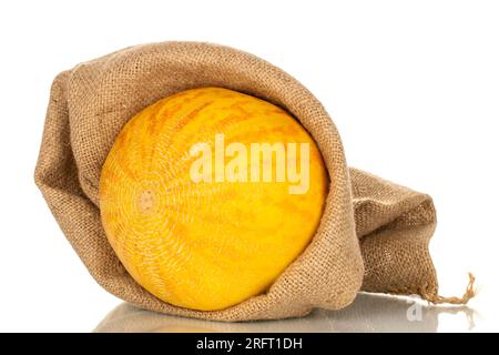 Eine gelbe Melone in einem Jutesack, Makro, isoliert auf weißem Hintergrund. Stockfoto