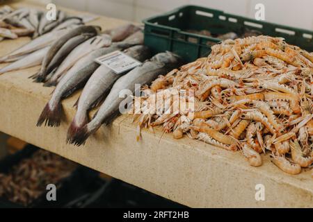 Frischer Fisch und Eisgarnelen auf dem traditionellen Fischmarkt. Selektiver Fokus. Stockfoto