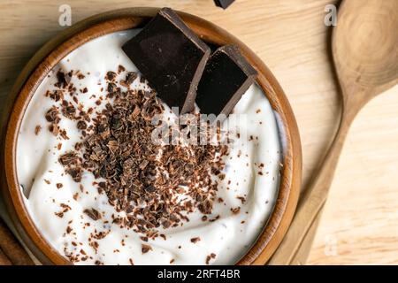Joghurt aus Sahne mit Schokoladenstücken und Krümeln, hausgemachter Joghurt aus Milchprodukten mit Milchschokolade Stockfoto