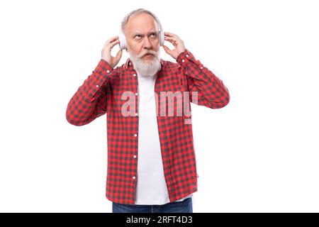 Musikliebhaber 60c pensionierter Mann mit weißem Bart und Schnurrbart mit Kopfhörern Stockfoto