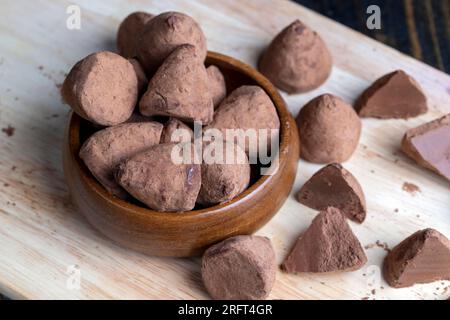 In Stücke schneiden Trüffelbonbons auf einem Brett, eine große Anzahl Pralinen mit Kakao, aufgeteilt in Stücke Stockfoto