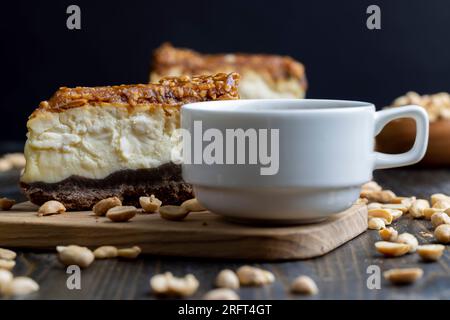 Käsekuchen aus Milchprodukten und Erdnüssen in Karamell, köstliches Dessert mit Erdnüssen, die in Stücke geschnitten werden, um in einem Café Tee zu machen Stockfoto