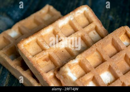 Quadratische süße, weiche Waffeln auf dem Tisch, ein traditionelles europäisches Dessert mit großen, weichen Waffeln Stockfoto