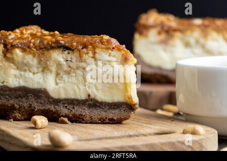 Käsekuchen aus Milchprodukten und Erdnüssen in Karamell, köstliches Dessert mit Erdnüssen, die in Stücke geschnitten werden, um in einem Café Tee zu machen Stockfoto