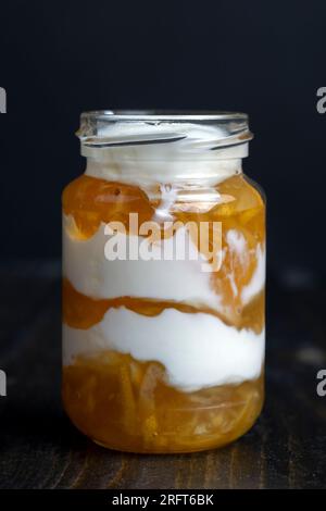 Joghurt aus frischer Milch mit süßer Zitronenmarmelade und frischen Zitronen, köstlicher Joghurt mit Zitronengeschmack Stockfoto