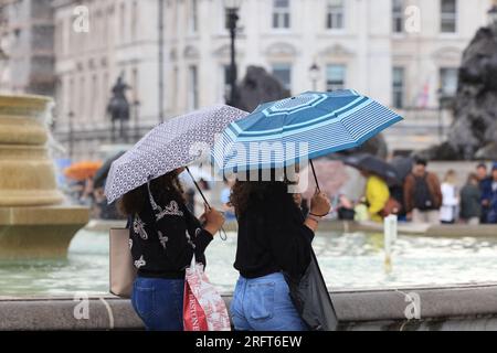 London, Vereinigtes Königreich, 5. August 2023. Unruhige Witterungsbedingungen dauern bis August an, mit kühlen Temperaturen und starken Regenschauern. Touristen brauchten ihre Koffer wegen der nassen Bedingungen am Trafalgar Square. Kredit : Monica Wells/Alamy Live News Stockfoto