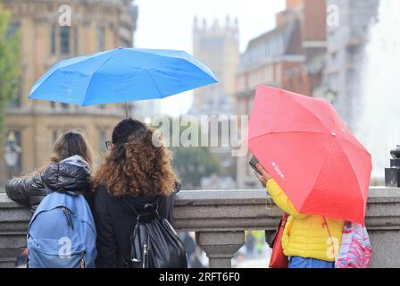 London, Vereinigtes Königreich, 5. August 2023. Unruhige Witterungsbedingungen dauern bis August an, mit kühlen Temperaturen und starken Regenschauern. Touristen brauchten ihre Koffer wegen der nassen Bedingungen am Trafalgar Square. Kredit : Monica Wells/Alamy Live News Stockfoto
