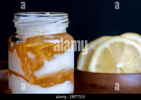 Joghurt aus frischer Milch mit süßer Zitronenmarmelade und frischen Zitronen, köstlicher Joghurt mit Zitronengeschmack Stockfoto