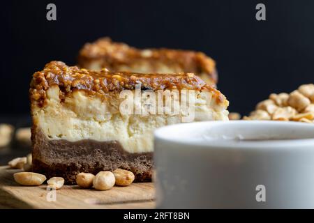 Käsekuchen aus Milchprodukten und Erdnüssen in Karamell, köstliches Dessert mit Erdnüssen, die in Stücke geschnitten werden, um in einem Café Tee zu machen Stockfoto