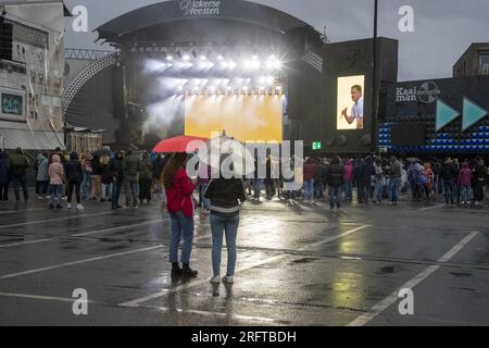 Lokeren, Belgien. 05. Aug. 2023. Die Abbildung zeigt Zuschauer, die während der Lokerse Feesten am Samstag, den 05. August 2023 in Lokeren im Regen eine Show mit Poncho und Regenschirm sehen. Das Festival findet vom 4. August bis 13. August statt. BELGA FOTO NICOLAS MAETERLINCK Kredit: Belga News Agency/Alamy Live News Stockfoto