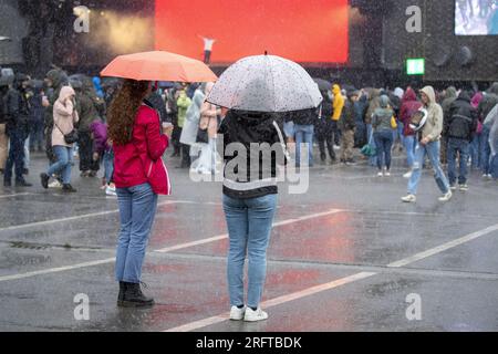 Lokeren, Belgien. 05. Aug. 2023. Die Abbildung zeigt Zuschauer, die während der Lokerse Feesten am Samstag, den 05. August 2023 in Lokeren im Regen eine Show mit Poncho und Regenschirm sehen. Das Festival findet vom 4. August bis 13. August statt. BELGA FOTO NICOLAS MAETERLINCK Kredit: Belga News Agency/Alamy Live News Stockfoto