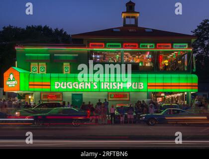 ROYAL OAK, MI/USA - 15. AUGUST 2015: Oldtimer fahren vorbei an einer nächtlichen Menschenmenge im beliebten Duggan's Irish Pub, Woodward Dream Cruise Route. Stockfoto