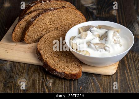 Gekochte Teigtaschen aus Teig mit Fleisch im Inneren, heiße und frisch gekochte Teigtaschen mit saurer Sahne Stockfoto