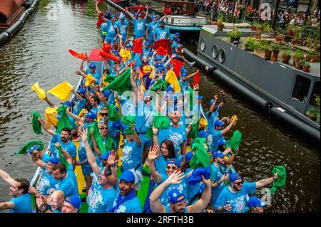 Amsterdam, Niederlande. 05. Aug. 2023. Menschen auf einem der Boote werden während des Ereignisses gesehen, wie sie mit Schals in verschiedenen Farben wedeln. Die Kanalparade beginnt gegen Mittag und dauert den ganzen Nachmittag. Rund 80 Schiffe verschiedener Organisationen und gemeinnützige Organisationen nehmen an der Veranstaltung Teil. Für die Grachtenparade ist Amsterdam Gay Pride berühmt. Es ist die Krönung ihres zweiwöchigen Festivals, das mehr als 200 Veranstaltungen umfasst. Die Boote starten am Scheepvaart-Museum im östlichen Teil des Stadtzentrums und fahren in Richtung Amstel. Kredit: SOPA Images Limited/Alamy Live News Stockfoto