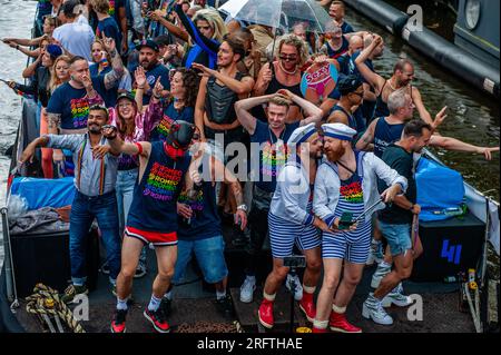 Amsterdam, Niederlande. 05. Aug. 2023. Zwei Männer werden beim Küssen gesehen, während sie während der Veranstaltung ein Selfie machen. Die Kanalparade beginnt gegen Mittag und dauert den ganzen Nachmittag. Rund 80 Schiffe verschiedener Organisationen und gemeinnützige Organisationen nehmen an der Veranstaltung Teil. Für die Grachtenparade ist Amsterdam Gay Pride berühmt. Es ist die Krönung ihres zweiwöchigen Festivals, das mehr als 200 Veranstaltungen umfasst. Die Boote starten am Scheepvaart-Museum im östlichen Teil des Stadtzentrums und fahren in Richtung Amstel. Kredit: SOPA Images Limited/Alamy Live News Stockfoto