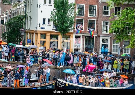 Amsterdam, Niederlande. 05. Aug. 2023. Tausende von Menschen treffen sich um den Kanal, um während der Veranstaltung Partys zu feiern. Die Kanalparade beginnt gegen Mittag und dauert den ganzen Nachmittag. Rund 80 Schiffe verschiedener Organisationen und gemeinnützige Organisationen nehmen an der Veranstaltung Teil. Für die Grachtenparade ist Amsterdam Gay Pride berühmt. Es ist die Krönung ihres zweiwöchigen Festivals, das mehr als 200 Veranstaltungen umfasst. Die Boote starten am Scheepvaart-Museum im östlichen Teil des Stadtzentrums und fahren in Richtung Amstel. Kredit: SOPA Images Limited/Alamy Live News Stockfoto